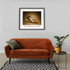Framed Bally Cinnamon Leather Pumps art print from the famous Imelda Marcos Shoe Collection displayed above a sofa in a contemporary living room.