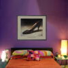 Framed Charles Jourdan Serenade Pump art print from the Imelda Marcos Shoe Collection displayed in a colourful bedroom.