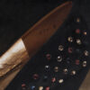 Close-up of Charles Jourdan Serenade Pump showing rhinestone jewels, black satin and gold metallic lining.