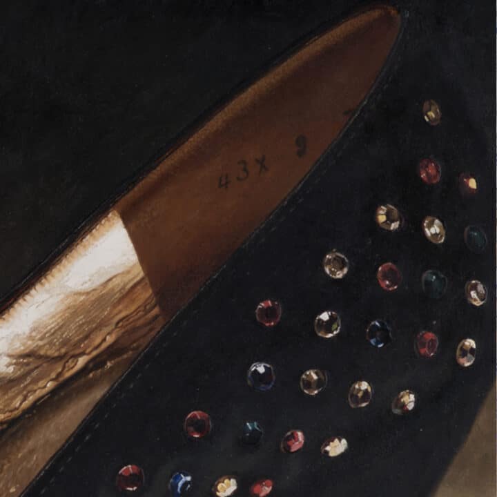 Close-up of Charles Jourdan Serenade Pump showing rhinestone jewels, black satin and gold metallic lining.