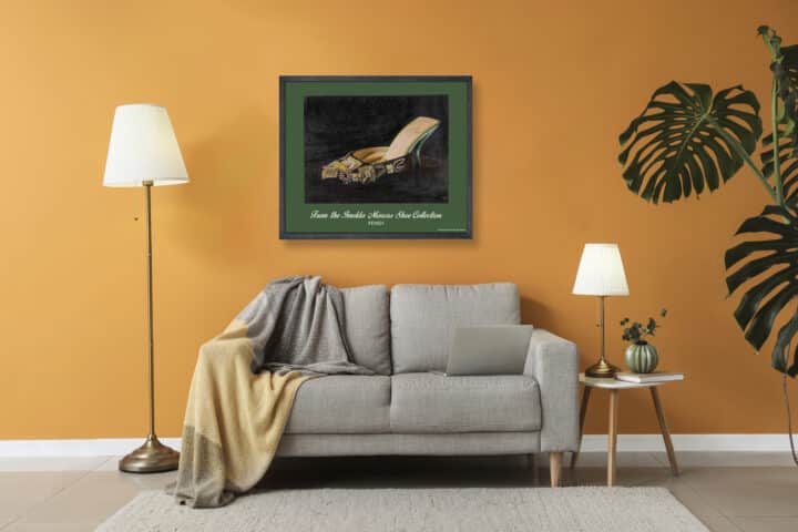Framed Fendi Imelda Marcos shoe print displayed above a sofa in an orange contemporary room setting