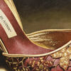 Close-up of Manolo Blahnik red satin heel showing gold floral embroidery, metallic gold lining, piping and Manolo Blahnik label.