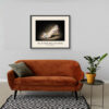 Oleg Cassini Polkadot Pumps art print displayed above an orange sofa, featuring white leather, multicoloured dots and decorative bow