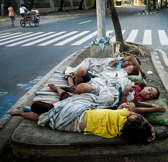 Group of children in Manila, Philippines, sleeping in the street, representing the vulnerable boys and girls supported through Imelda Marcos Shoe Artwork humanitarian project.