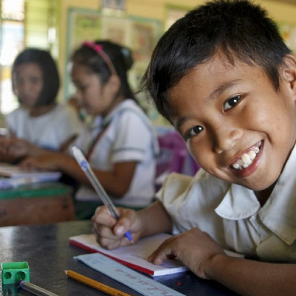Boy in school in Manila after receiving support to move away from life on the streets.