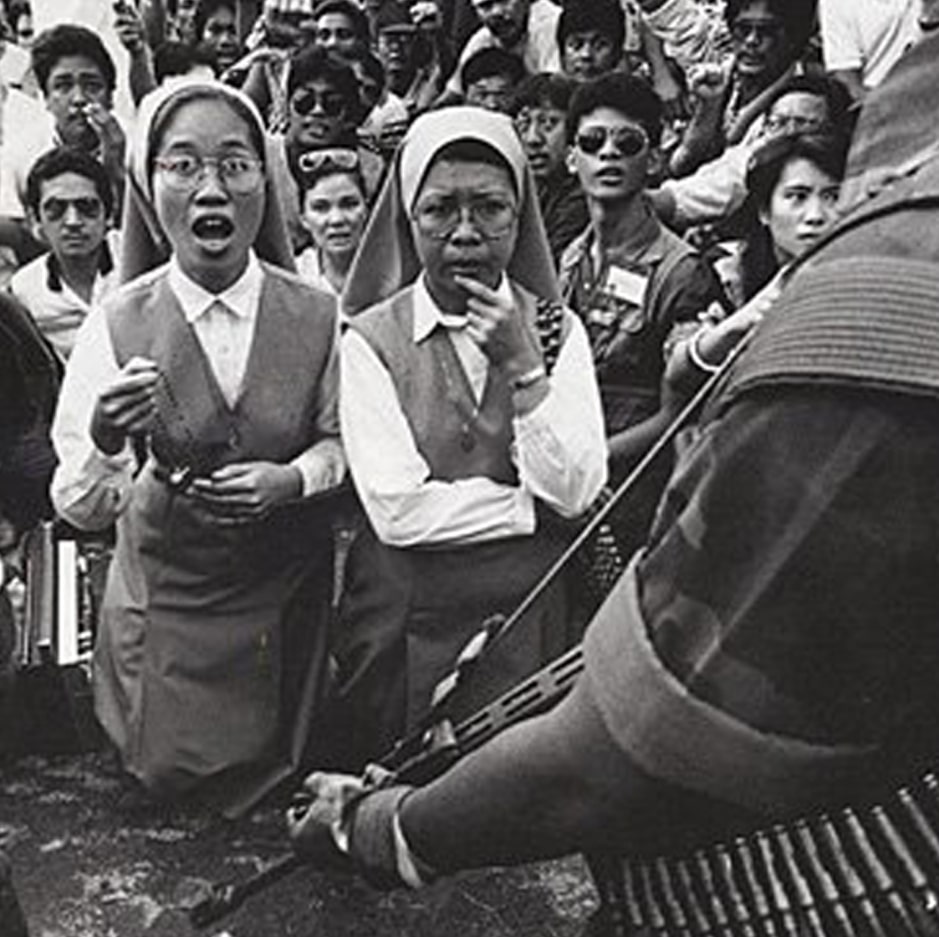 Catholic nuns and civilians face an armed soldier during political unrest in the Philippines during the Marcos era.